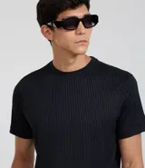 Remera de manga corta color beige, corte slim, con cuello redondo y textura acanalada vertical.