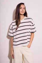 Remera de algodón color crudo con rayas horizontales negras, corte holgado y mangas cortas.