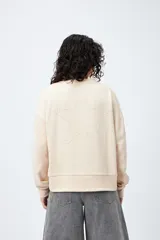 Buzo color marrón de corte relajado confeccionado en tejido de algodón con interior suave al tacto. Presenta detalle de estrella con tachas en la espalda y bordado delantero con la frase Dreamer – Born to rock.