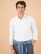 Camisa blanca de hombre, corte regular fit, cuello button-down, cierre con botones, manga larga terminada en puño simple y logo bordado en el pecho.