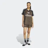 Remera Adidas Originals de satén con estampado animal print, cuello en V acanalado y mangas cortas negras con las clásicas tres tiras blancas. Cuenta con el logo de la marca estampado en el frente.