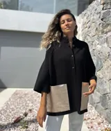 Saco tejido de punto en color negro, con corte holgado y mangas tres cuartos. Presenta bolsillos frontales amplios confeccionados en cuero metalizado color plateado y cierre frontal con botones.