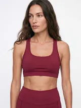 Top deportivo negro con diseño de espalda deportiva y escote redondo.