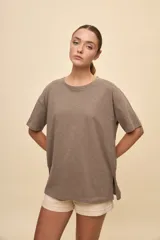 Remera negra de calce amplio, confeccionada en algodón liviano, con cuello redondo, mangas cortas y hombros levemente caídos.