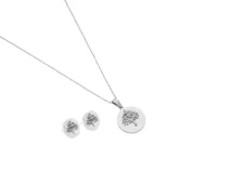 Set de acero plateado que incluye un collar con dije circular calado con el diseño del árbol de la vida y un par de caravanas con el mismo diseño.