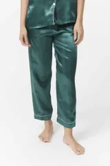 Conjunto de pijama verde esmeralda de satén con ribetes blancos, compuesto por camisa de manga corta con botones y pantalón capri.