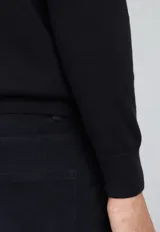 Sweater de algodón color verde petróleo, con cuello redondo y mangas largas.