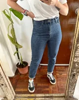 Jeans baggy tiro alto de color azul, confeccionados en denim, con diseño clásico de cinco bolsillos y botamangas con dobladillo.