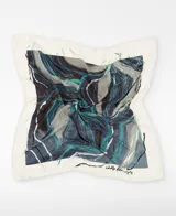 Maxi pañuelo de seda mulberry 100% firmado por Adolfo Domínguez, con diseño estampado de motivos de ajo en tonos gris, azul y turquesa sobre fondo blanco, y dobladillo hecho a mano.