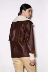 Chaqueta estilo blazer color marrón con flecos en la parte delantera y trasera, solapas y bolsillos frontales.