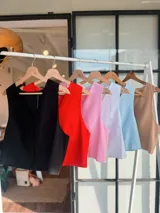 Chaleco sin mangas color rosa claro, con escote en V y cierre frontal de botones a tono.