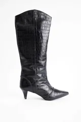 Bota de caña alta confeccionada en cuero vacuno con textura de reptil. Presenta un diseño de punta fina y un tacón bajo tipo kitten heel.