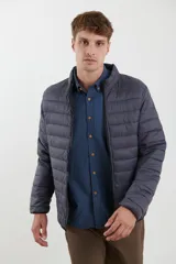 Campera puffer azul marino con cierre frontal, cuello alto y bolsillos laterales con cierre.