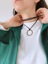 Gargantilla choker con doble tira fina de cordón negro y dije de aro dorado.