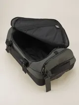 Valija gris con ruedas, manija extensible y múltiples bolsillos con cierre.