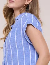 Camisa de lino azul a rayas blancas, sin mangas, con cuello camisero, escote en V y botones frontales.