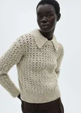 Jersey de punto calado con textura gruesa, cuello polo y terminaciones de canalé en puños y ruedo.