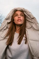 Anorak corto acolchado de Zara, color beige, con cuello subido, capucha, manga larga con puños elásticos y cierre frontal cruzado con botones magnéticos.