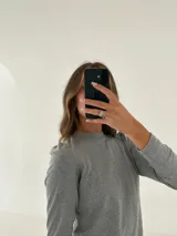 Remera gris de morley de algodón, manga larga con detalle fruncido en el hombro.