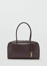 Bolso de mano de poliuretano color marrón oscuro, con doble asa para el hombro, herrajes metálicos dorados y detalle de llavero decorativo con candado y llaves.