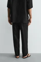 Pantalón relaxed fit de lino color negro, con cintura elástica ajustable con cordón y bolsillos frontales.