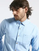 Camisa de manga larga en color celeste, con cuello button-down, bolsillo frontal y botones de madera.