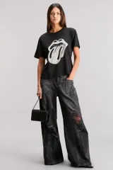 Remera negra de jersey de algodón, con cuello redondo y manga corta. Presenta una estampa frontal del logo de los Rolling Stones en blanco y gris, y un estampado en la espalda.