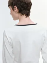 Remera de manga larga entallada, confeccionada en algodón elastizado. Presenta cuello redondo en color blanco a contraste y un detalle de estrella central compuesta por brillos.