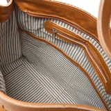 Cartera tipo hobo de cuero color suela con diseño tejido.