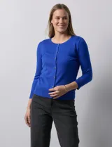 Cardigan blanco de tejido fino con abertura central y botones.