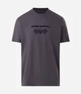Remera gris oscuro de algodón, con cuello redondo y mangas cortas. Presenta un estampado frontal localizado con la inscripción "Avenged Sevenfold" y una calavera con alas.