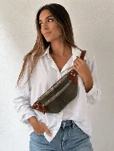 Riñonera de cuero color negro, con múltiples compartimentos con cierre metálico, detalles de tachas en los laterales y correa regulable.