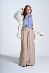 Sacón de hilado frizado color crudo, con calado delicado y bolsillos tejidos al frente. De corte relajado.