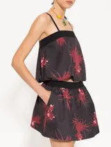 Mini falda negra con estampado de flores rojas, cintura elastizada y bolsillos laterales.