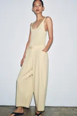 Pantalón de tiro medio confeccionado en mezcla de lyocell, con diseño de pierna ancha y tejido en espiga. Cuenta con cintura elástica ajustable con cordones y bolsillos laterales.