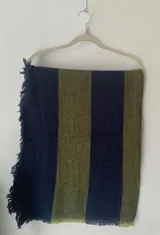 Bufanda de gran tamaño en color azul marino con detalles en verde lima, con diseño de tejido texturizado y bordes desflecados.