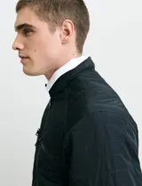 Campera de estilo casual con cierre frontal, cuello alto con broche y bolsillos laterales con cierre. Presenta un diseño liso y funcional, ideal para uso diario.