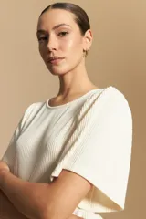 Remera de rib con cuello redondo y mangas cortas amplias con leve frunce en los hombros. Confeccionada en tejido elastizado de textura acanalada.