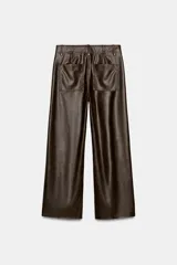 Pantalón de tiro alto color marrón oscuro con efecto piel, pierna ancha y costura marcada en el delantero. Incluye bolsillos de plastrón en la espalda y cierre frontal con cremallera, botón y gancho metálico.