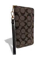 Billetera tipo sobre con correa de muñeca, confeccionada en material sintético con estampado monograma en tonos gris y negro. Cuenta con cierre perimetral y herrajes metálicos dorados.