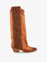 Bota de caña alta de cuero color marrón caramelo, con puntera fina y taco ancho bajo de madera. Presenta un panel lateral de cuero trenzado en tono marrón oscuro.