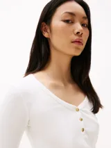 Remera blanca de algodón con textura acanalada, corte slim, cuello redondo con tapeta de botones dorados y manga larga.