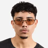 Lentes de sol con marco metálico fino de forma ovalada y cristales en tono ámbar. Cuentan con protección UV400.