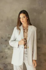 Blazer sastrero de corte recto y fit relajado, confeccionado en lino con hilos de lurex. Presenta solapas clásicas, hombreras, cierre frontal con un botón de nácar y bolsillos laterales con solapa.