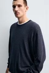 Jersey de punto con diseño de rayas horizontales finas, cuello redondo y manga larga. Presenta un corte regular fit con terminaciones en rib en cuello, puños y ruedo.