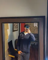 Sweater de punto azul marino con cuello alto y medio cierre metálico. Presenta un diseño de fit relajado con el logo "R" tejido en gran tamaño en el pecho.