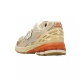 Championes urbanos New Balance modelo 1906, con diseño técnico de running. Presentan una combinación de tonos beige y crema en el cuerpo de malla y superposiciones sintéticas, con detalles en color naranja en la entresuela y logotipos. Cuentan con suela de goma y tecnología de amortiguación.