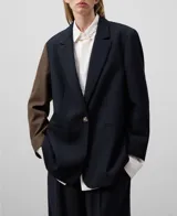 Blazer bicolor con manga larga, solapa, cierre de un botón y bolsillos de vivo en delantero.