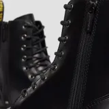 Botas de plataforma Dr. Martens modelo Jadon, confeccionadas en cuero negro con acabado liso. Presentan el diseño clásico de 8 ojales con cordones, pespuntes amarillos en la base, suela Quad de alta resistencia y cierre lateral para facilitar el calce.