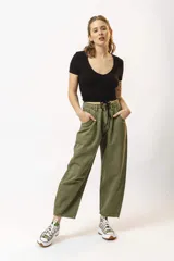 Pantalón de jean color verde oliva, de corte holgado y tiro alto, con pinzas en la cintura y bolsillos laterales.